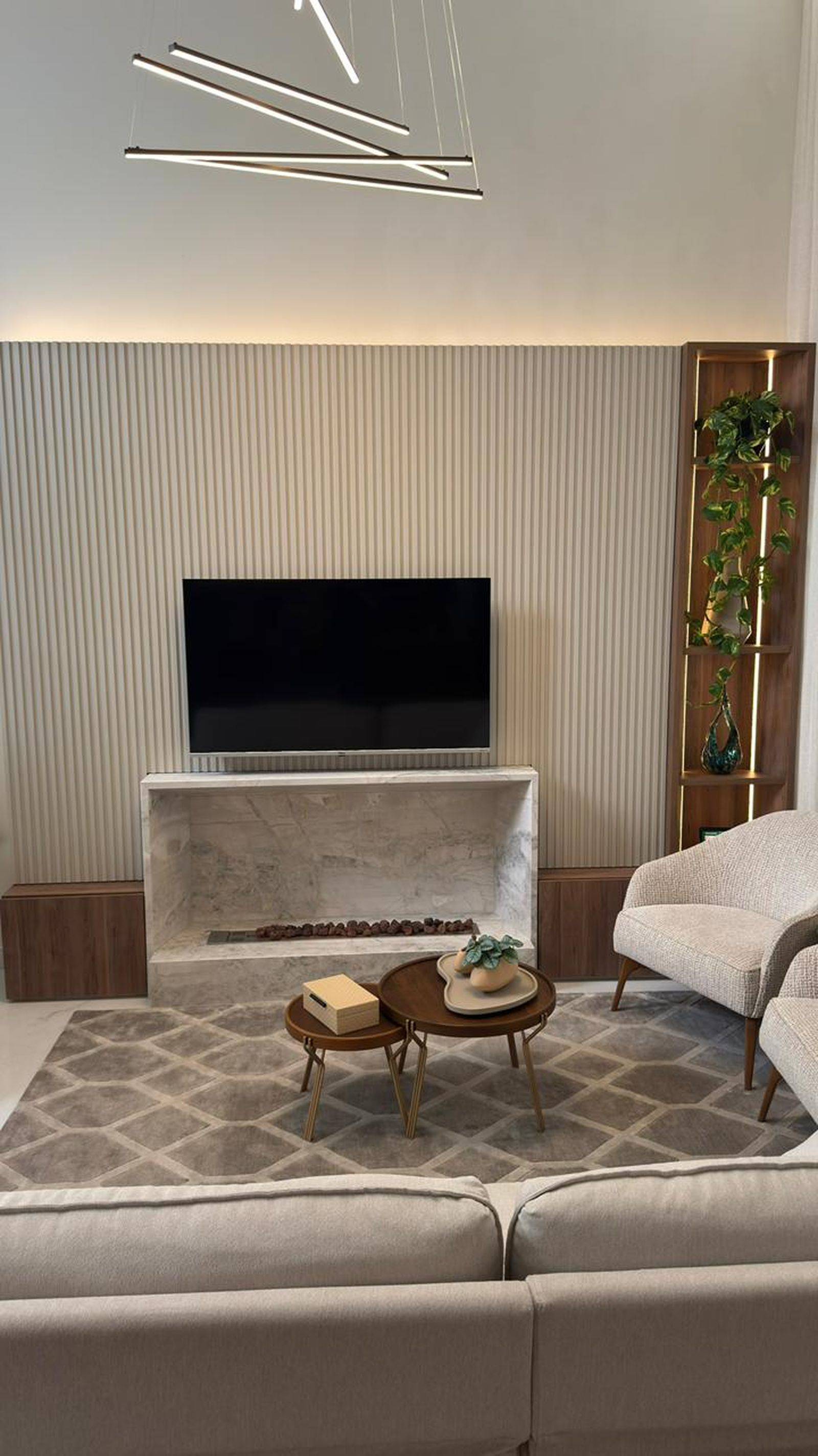 Lareira em mármore branco Paraná com moldura volumétrica e contraste com painel em madeira.